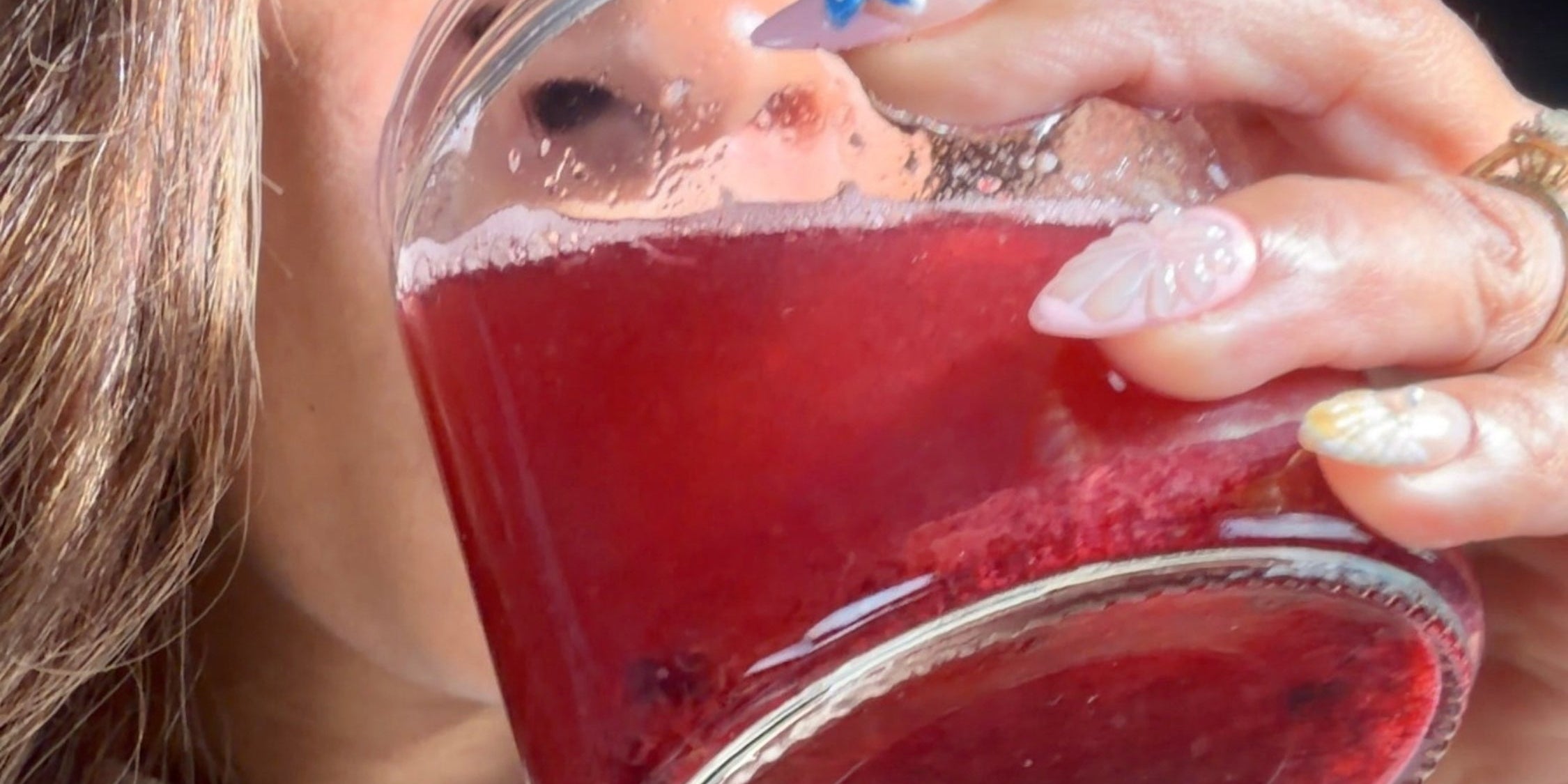 woman drinking blueberry sea moss lemoade