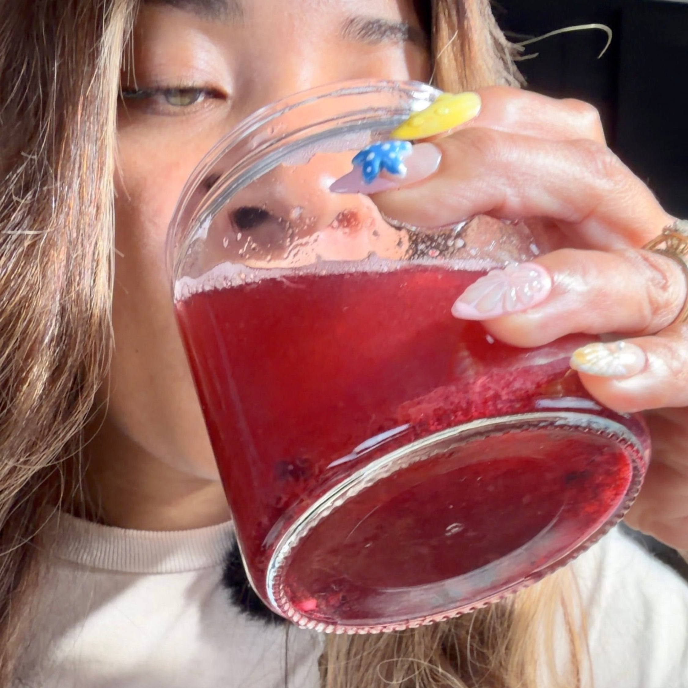 woman drinking blueberry sea moss lemoade