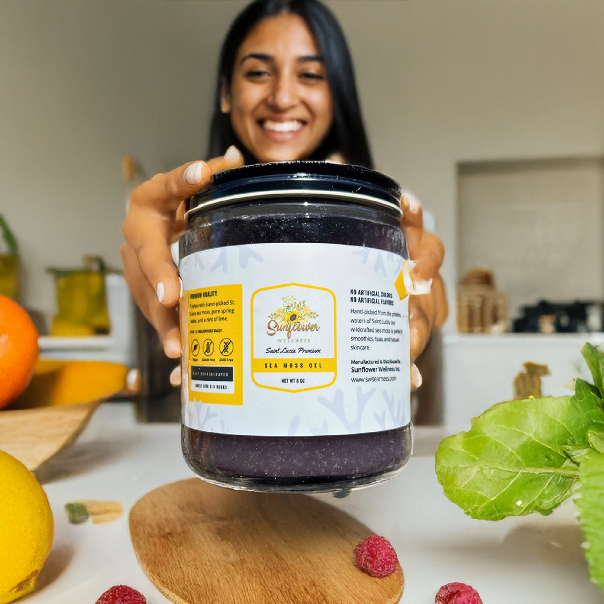 Smiling woman holding a jar of Sunflower Wellness Full Spectrum Sea Moss Gel, showcasing its rich natural color and premium quality.